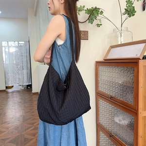 Détail du sac hobo noir à rayures verticales montrant sa grande capacité
