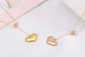 Detail of gold and rose gold heart pendant necklaces with a polished metallic finish