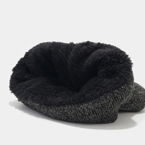 Detailed view of the thick black faux fur lining inside the grey knitted winter beanie
