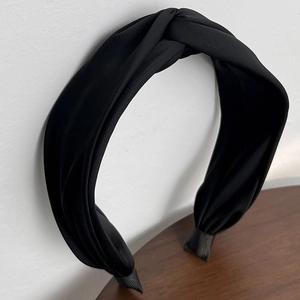 Close-up of black satin twisted headband with elegant ribbed fabric end wraps