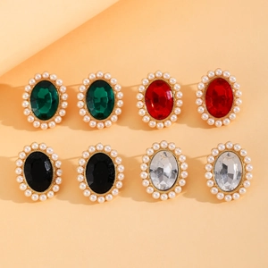 Détail de boucles d'oreilles vintage dorées avec pierres ovales et bordures en perles