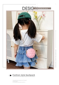 Close-up of pink round crossbody bag for girls featuring heart quilted patterns and gold chain