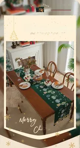 Detail of green Christmas table runner with festive prints and elegant black tassels
