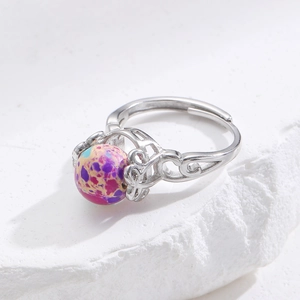 Makro-Detailansicht des silbernen Rings mit Hohlmuster und buntem Naturstein-Perle