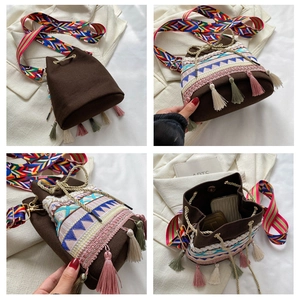 Ethnic style bucket bag with colorful woven patterns, tassels, and wide shoulder strap detail