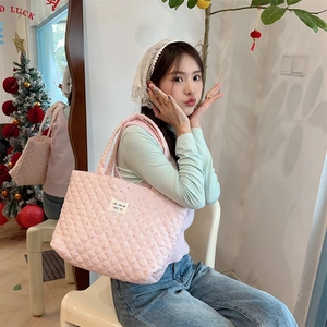 Pink quilted tote bag shown on a shoulder in a cozy interior setting for daily lifestyle