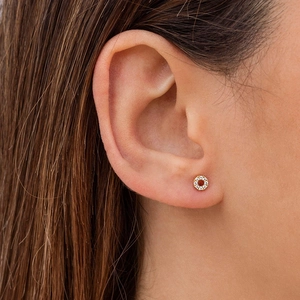Golden round geometric stud earrings with micro-set zircon stones on model's ear