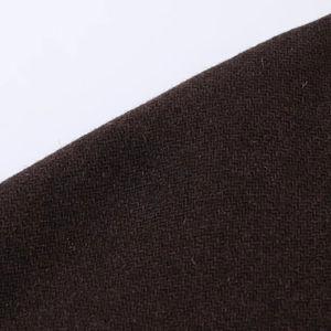 Macro shot of dark brown twill wool fabric texture showing detailed woven fiber pattern