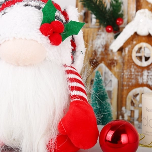 Close-up of a plush glowing Christmas gnome with red berries and knit hat decoration