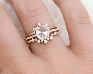 Macro detail of rose gold ring set featuring rose cut center stone and micro pavé diamonds