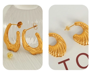 Detailed macro view of golden irregular geometric and textured thread earrings with metallic shine