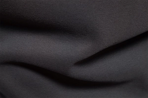 Macro shot of dark grey knit fabric texture showing softness and premium material detail