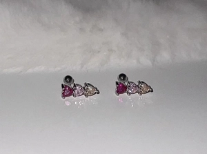 Detailed view of silver heart-shaped stud earrings with pink gradient zircon stones