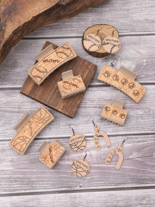 Detail showing natural wood earrings and hair clips with engraved festive patterns