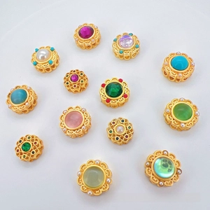 Macro detail of antique gold plated beads with colorful cat eye stones and pearls