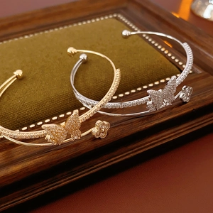 Detailed close-up of double-layer zircon butterfly bangle with gold and silver finishes