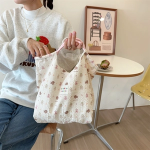 Detail of waffle fabric texture and cartoon rabbit print on a cream canvas tote bag