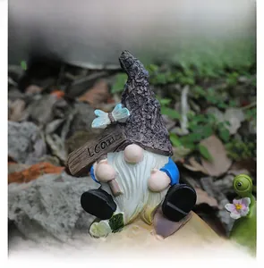 Garden gnome statue with tree bark hat and blue suit holding Welcome sign with butterfly