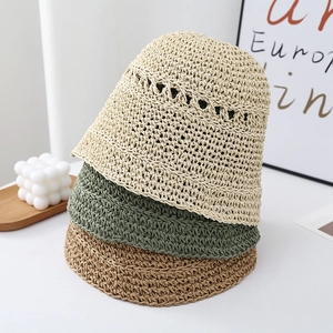 Detail of woven straw bucket hats in beige, green, and khaki with a fine texture