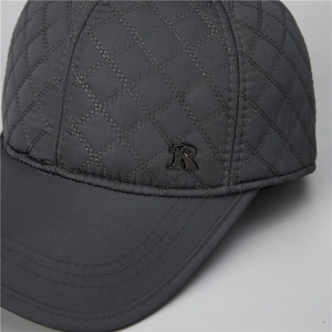 Close-up of dark grey quilted baseball cap with diamond pattern and metal R logo