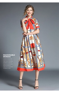 Detail of bohemian floral midi dress featuring red bow neckline and short sleeves