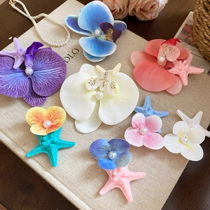 Detailed macro view of starfish and fabric flower hair clips with pearls on a book