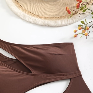 Détail du maillot de bain marron foncé avec découpes et texture en tricot élastique