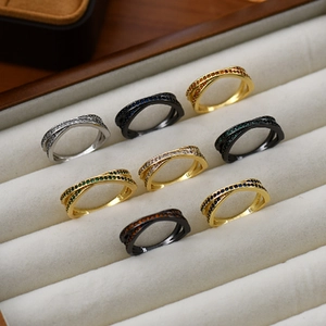Crisscross design rings in gold, silver and black metal set with colorful gemstones