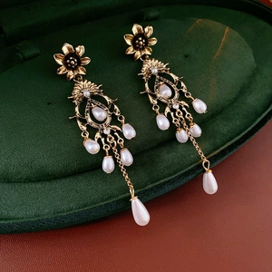 Close-up of vintage flower earrings with pearls in a luxury green velvet jewelry box