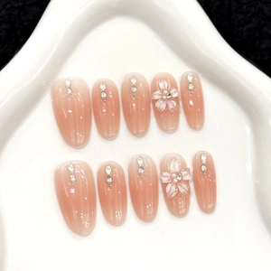 3D floral press-on nails with pink gradient and pearl accents in a star plate