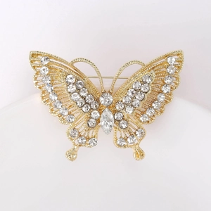 Detailed macro of a vintage gold butterfly brooch with inlaid sparkling rhinestones