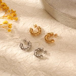 Twisted rope texture hoop earrings in gold and silver finish on a neutral aesthetic background
