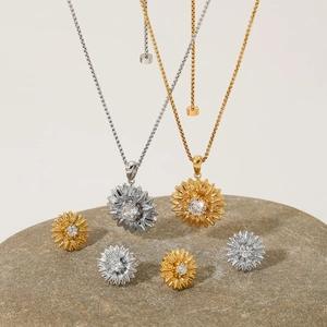 Schmuckset mit Blumen-Zirkonia-Halskette und Ohrringen in Gold und Silber auf Stein