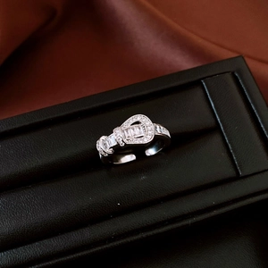 Macro shot of adjustable silver belt buckle ring with sparkling rectangular zircons
