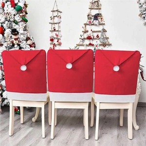 Three red non-woven Christmas chair covers in Santa hat design for holiday dining decor