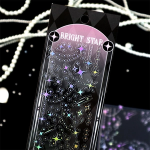 Close-up of holographic silver star stickers with BRIGHT STAR laser effect on black background