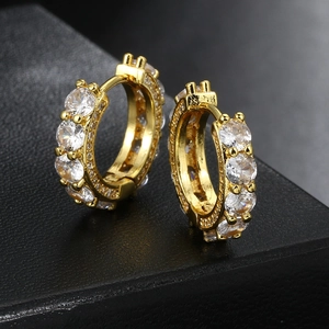 Golden hip hop hoop earrings with micro-paved round cubic zirconia on black surface