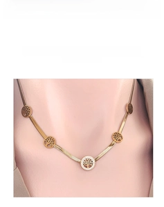 Close-up of golden flat snake chain with sparkling crystal tree of life pendants