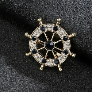 Nautical ship wheel brooch pin in gold finish with dark blue and white rhinestones