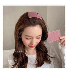 Close-up of pink magic hair pads securing bangs on model for daily hairstyling