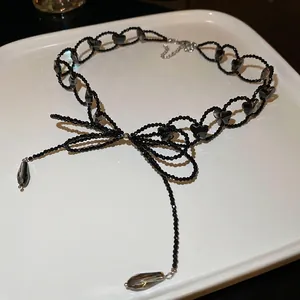 Elegant black glass beaded bow necklace with teardrop pendant in a modern chic style