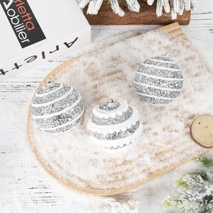 Close-up of three striped silver glitter and white fuzz Christmas ball ornaments with hooks