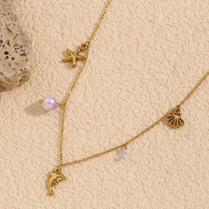 Detail of 18K gold-plated ocean necklace with starfish, dolphin and pearl charms