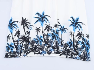 Detail of tropical palm tree print on white lightweight fabric hem for summer dress