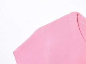 Close-up of pink knit fabric texture with detailed stitching on a short sleeve top