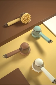 Close-up of four silicone pet bath brushes in yellow, green, brown, and white with metal hooks