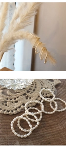 Detail of handmade natural freshwater pearl rings and bracelets on lace and wood