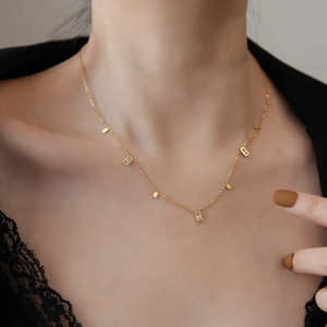 Elegant gold choker necklace with rectangular crystal pendants on a female model