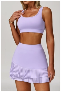 Details des hellvioletten Yoga-Sport-BHs und des plissierten Tennisrocks am Model