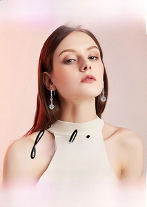 Detailed view of elegant S925 silver moissanite drop earrings worn by a model